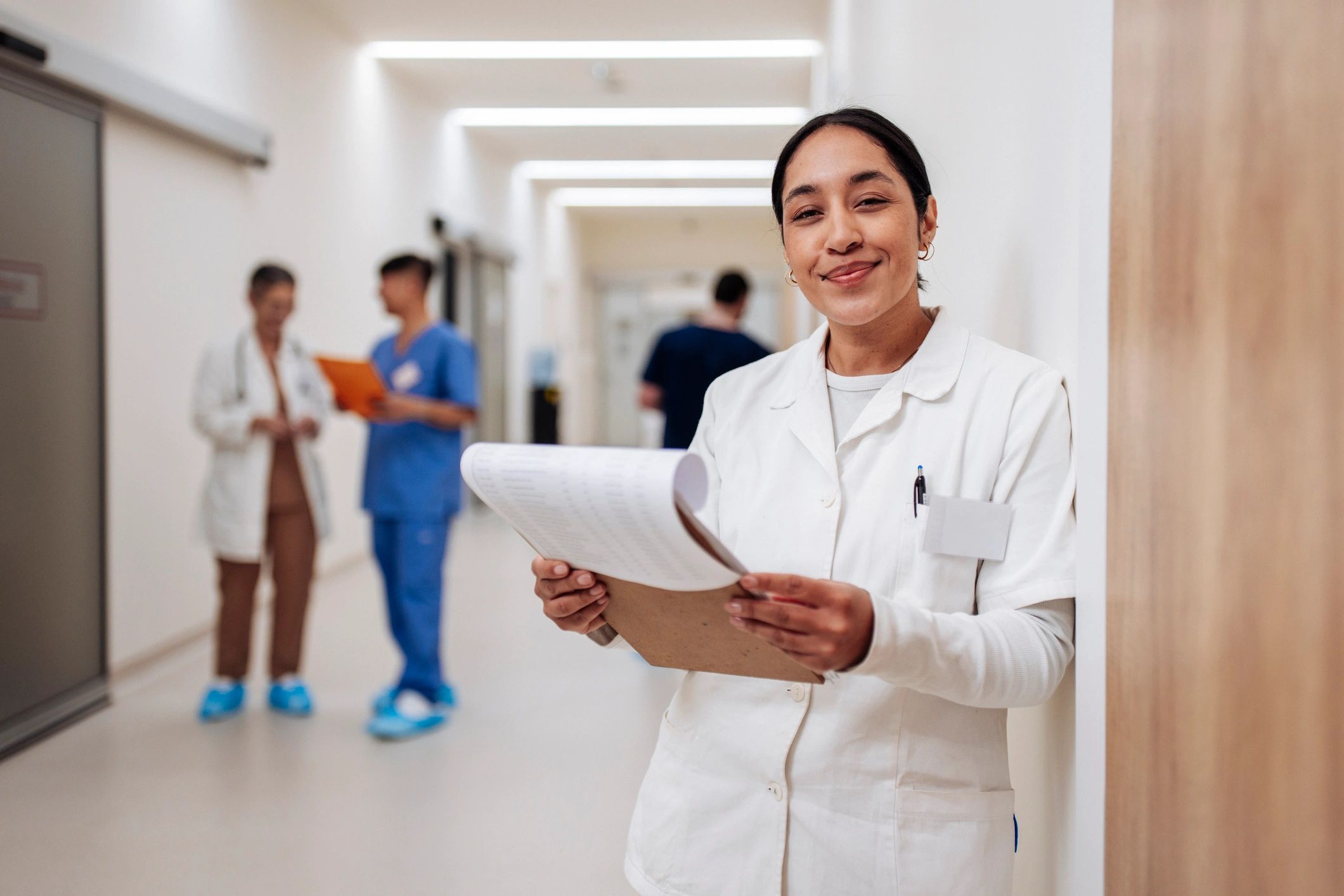Medical content lead holding paperwork in a hospital corridor